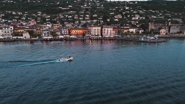 Aerial view of a boat on Lake Garda near a coastal town Italy. Aerial view of a boat on Lake Garda near a coastal town Italy.