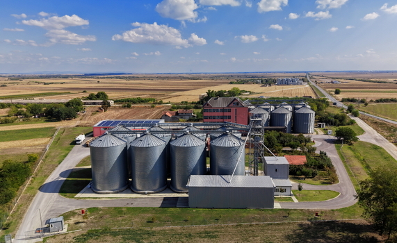 Aerial view of Silo Bavaniste featuring large metal grain silos and industrial buildings surrounded by expansive agricultural fields in Bavaniste Vojvodina Serbia.