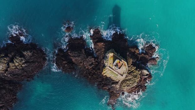 Aerial view of Phare de L Ost Pic on a rocky islet France.