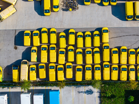 Aerial view of the Logistikzentrum Allhaming featuring rows of yellow delivery vans parked in a large paved lot in Allhaming Oberosterreich Austria. Aerial view of the Logistikzentrum Allhaming featuring rows of yellow delivery vans parked in a large paved lot in Allhaming Oberosterreich Austria.