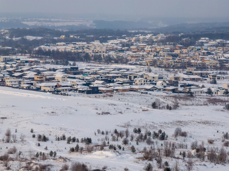 Aerial view of modern residential houses and snow covered fields under a winter sky in Lithuania. Aerial view of modern residential houses and snow covered fields under a winter sky in Lithuania.