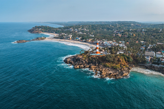 Aerial view of Vizhinjam Lighthouse on a rocky cliff overlooking the Arabian Sea and sandy beaches in Kovalam Kerala India. Aerial view of Vizhinjam Lighthouse on a rocky cliff overlooking the Arabian Sea and sandy beaches in Kovalam Kerala India.