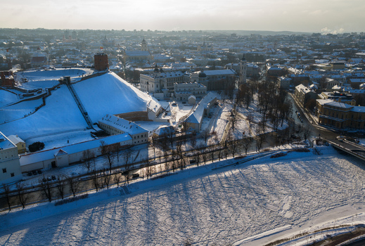 Aerial view of Gediminas Tower on a snow covered hill overlooking the frozen Neris River and the historic old town under a bright winter sun Vilnius County Lithuania.