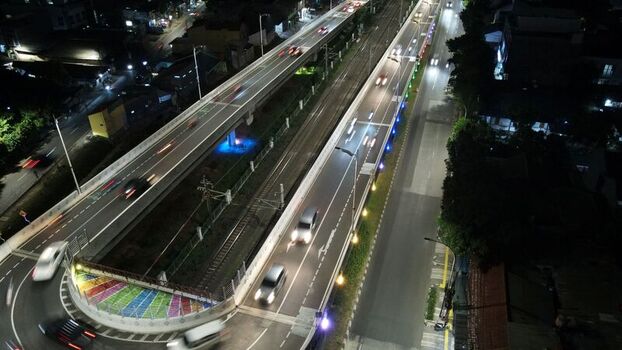 Aerial view of Flyover Tapal Kuda Jakarta at night with colorful illuminated curves traffic on the elevated road and city lights in Pasar Minggu Daerah Khusus Ibukota Indonesia. Aerial view of Flyover Tapal Kuda Jakarta at night with colorful illuminated curves traffic on the elevated road and city lights in Pasar Minggu Daerah Khusus Ibukota Indonesia.