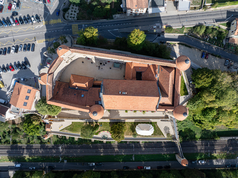 Aerial view of the historic Chateau de Grandson with its terracotta rooftops stone walls and courtyard situated near the railway tracks in Grandson Vaud Switzerland.