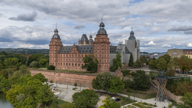 Aerial view of Schloss Johannisburg with its red sandstone facade towers and surrounding gardens situated along the Main river in Aschaffenburg Bayern Germany.