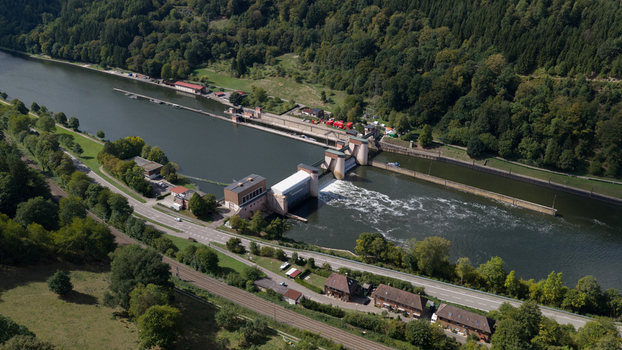 Aerial view of the Neckar Staustufe und Schleuse Rockenau dam and lock system on the Neckar River surrounded by forests and a road in Eberbach Baden Wurttemberg Germany.