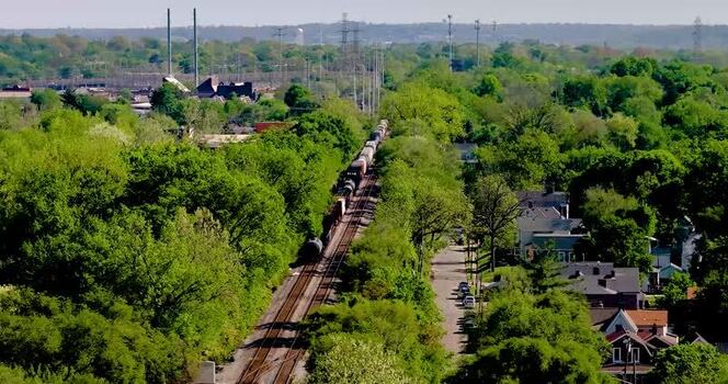 Aerial view of a freight train passing through trees United States. Aerial view of a freight train passing through trees United States.