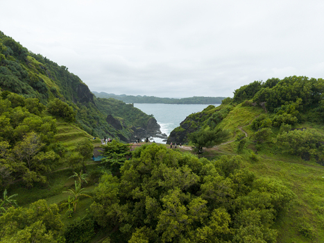 Aerial view of the dramatic coastline where lush green hills meet the turquoise sea creating a stunning contrast of nature s beauty Gunungkidul Regency Daerah Istimewa Yogyakarta Indonesia. Aerial view of the dramatic coastline where lush green hills meet the turquoise sea creating a stunning contrast of nature s beauty Gunungkidul Regency Daerah Istimewa Yogyakarta Indonesia.