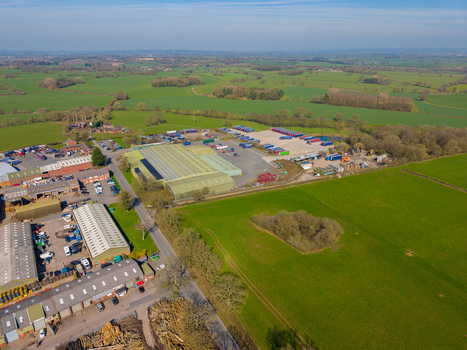 Aerial view of Ladfordfields Industrial Estate with warehouses parked trucks and surrounding green fields in Stafford England United Kingdom. Aerial view of Ladfordfields Industrial Estate with warehouses parked trucks and surrounding green fields in Stafford England United Kingdom.