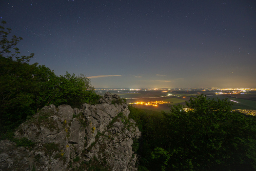 View of Havrania skala in the Male Karpaty mountains overlooking city lights in the valley under a starry night sky Smolenice Trnava Region Slovakia. View of Havrania skala in the Male Karpaty mountains overlooking city lights in the valley under a starry night sky Smolenice Trnava Region Slovakia.