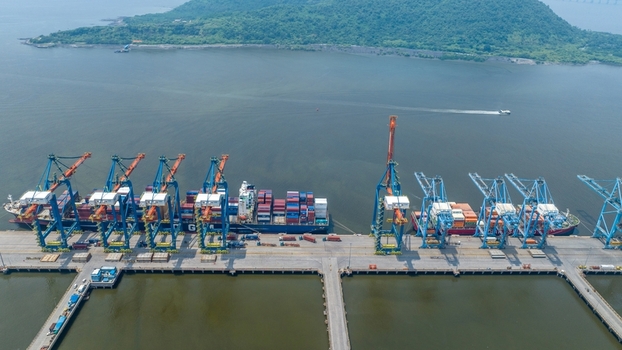 Aerial view of Jawaharlal Nehru Port Authority with large container ships docked at the pier multiple tall cranes and calm water in Juna Sheva Maharashtra India. Aerial view of Jawaharlal Nehru Port Authority with large container ships docked at the pier multiple tall cranes and calm water in Juna Sheva Maharashtra India.