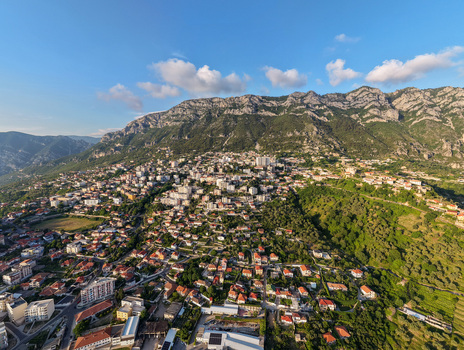 Aerial view of the historic town with red tiled roofs and modern buildings nestled at the foot of a rugged mountain range in Kruje Durres County Albania.