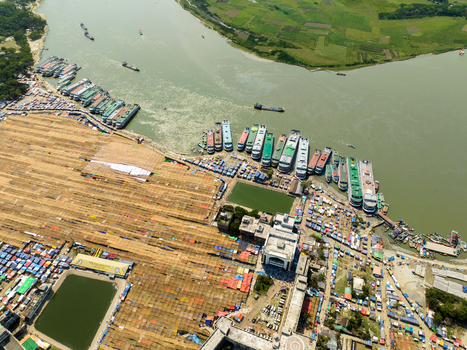 Aerial view of a bustling river port with vessels lining the shore contrasting the earthy tones of the land with the gleaming waters Charmonai Bangladesh. Aerial view of a bustling river port with vessels lining the shore contrasting the earthy tones of the land with the gleaming waters Charmonai Bangladesh.