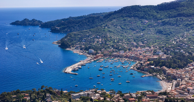 Aerial view of the picturesque harbor filled with yachts and boats along the colorful coastal town and lush green hills in Santa Margherita Ligure Liguria Italy. Aerial view of the picturesque harbor filled with yachts and boats along the colorful coastal town and lush green hills in Santa Margherita Ligure Liguria Italy.