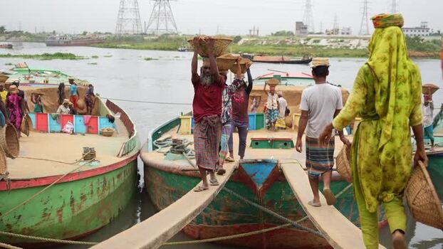 View of workers carrying baskets from boats at Aminbazar Bangladesh.