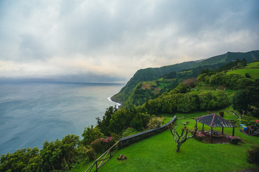 Aerial view of the rugged coastline where the verdant hills meet the deep blue sea under a dramatic sky Azores Azores Portugal.