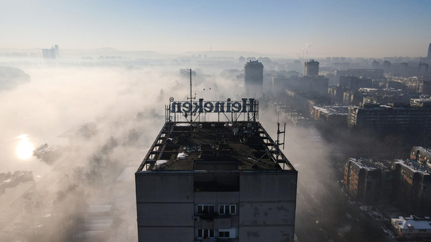 Belgrade City of Belgrade Serbia 16 January 2022 Aerial view of a high rise building with a Heineken sign on the roof surrounded by dense morning fog over the urban landscape. Belgrade City of Belgrade Serbia 16 January 2022 Aerial view of a high rise building with a Heineken sign on the roof surrounded by dense morning fog over the urban landscape.