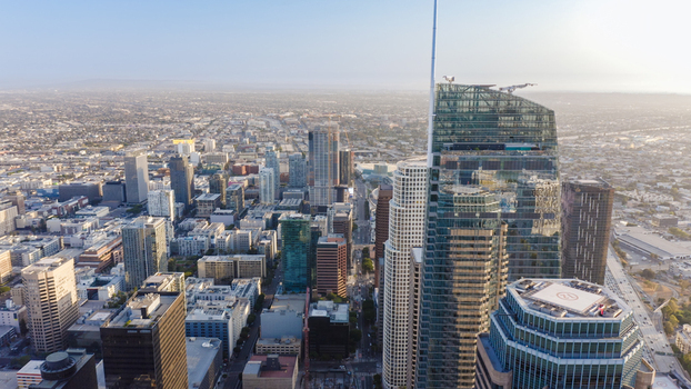 Aerial view of the Wilshire Grand Center towering over the dense urban skyline with modern skyscrapers and city streets in Los Angeles California United States.