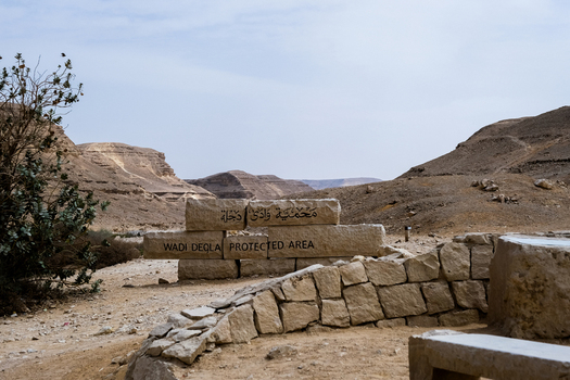 View of the Wadi Degla Protected Area where the stark desert landscape meets the rugged stone formations under a vast sky Cairo Cairo Governorate Egypt. View of the Wadi Degla Protected Area where the stark desert landscape meets the rugged stone formations under a vast sky Cairo Cairo Governorate Egypt.
