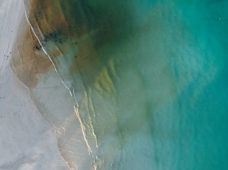 Aerial view of the shoreline where the sandy beach meets the turquoise waters Pantai Tanjung Aan West Nusa Tenggara Indonesia. Aerial view of the shoreline where the sandy beach meets the turquoise waters Pantai Tanjung Aan West Nusa Tenggara Indonesia.