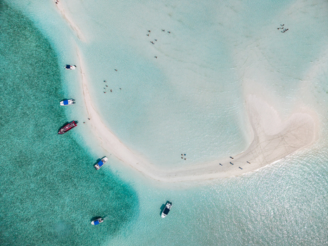 Aerial view of Man O War Cay Sandbar with anchored boats and people swimming in turquoise waters in Rolletown Exuma The Bahamas. Aerial view of Man O War Cay Sandbar with anchored boats and people swimming in turquoise waters in Rolletown Exuma The Bahamas.