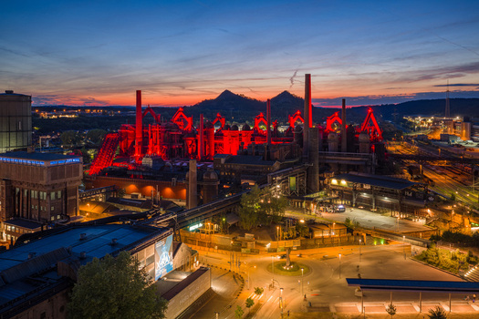 Volklingen Germany 09 May 2026 Aerial view of the Volklingen Ironworks illuminated with red lights against a twilight sky with blast furnaces and tall chimneys. Volklingen Germany 09 May 2026 Aerial view of the Volklingen Ironworks illuminated with red lights against a twilight sky with blast furnaces and tall chimneys.