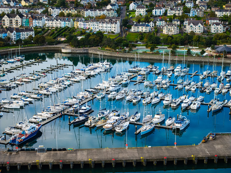 Aerial view of Bangor Harbour and Town with numerous sailboats and yachts moored in the marina surrounded by coastal buildings and lush greenery in Bangor Northern Ireland United Kingdom.