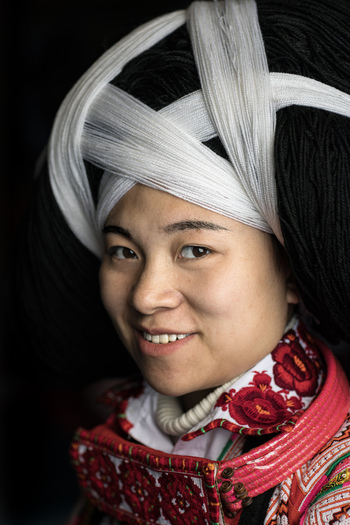 Gaoxing China 30 April 2026 View of a smiling woman from the Long Horn Miao ethnic group wearing a traditional large headpiece and embroidered clothing. Gaoxing China 30 April 2026 View of a smiling woman from the Long Horn Miao ethnic group wearing a traditional large headpiece and embroidered clothing.