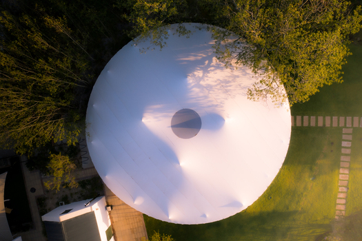 Aerial view of a large white circular marquee tent surrounded by lush green lawn and trees during golden hour Cape Town Western Cape South Africa. Aerial view of a large white circular marquee tent surrounded by lush green lawn and trees during golden hour Cape Town Western Cape South Africa.