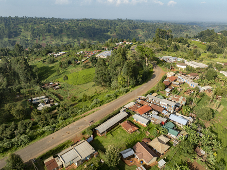 Aerial view of a ribbon of road cuts through verdant hills lined with clustered buildings amidst the lush landscape Nyeri Nyeri Kenya. Aerial view of a ribbon of road cuts through verdant hills lined with clustered buildings amidst the lush landscape Nyeri Nyeri Kenya.