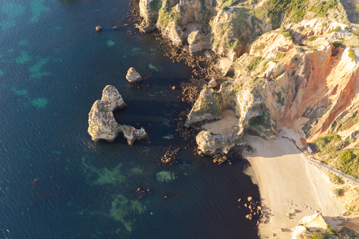 Aerial view of the dramatic limestone cliffs sea stacks and turquoise waters of Ponta da Piedade in Lagos Faro District Portugal.