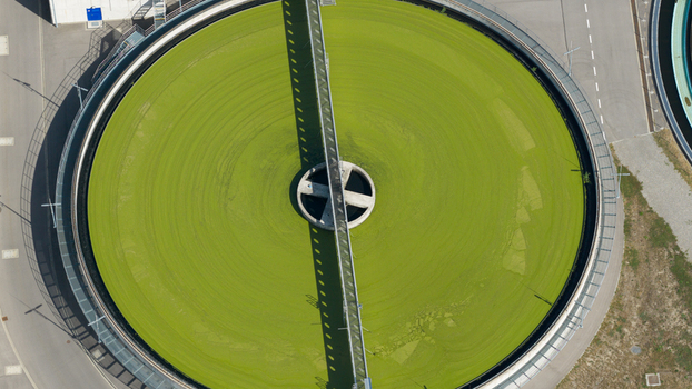 Aerial view of the circular sedimentation tank at the Klarwerk Karlsruhe wastewater treatment plant with green water and a central bridge structure in Karlsruhe Baden Wurttemberg Germany.