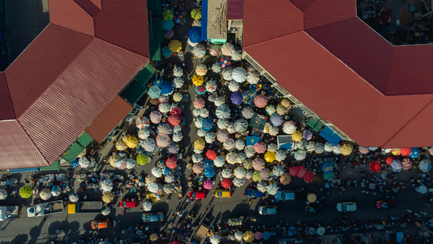 Accra Ghana 26 May 2023 Aerial view of a bustling outdoor market with numerous colorful umbrellas crowded stalls and vehicles navigating the busy streets below. Accra Ghana 26 May 2023 Aerial view of a bustling outdoor market with numerous colorful umbrellas crowded stalls and vehicles navigating the busy streets below.