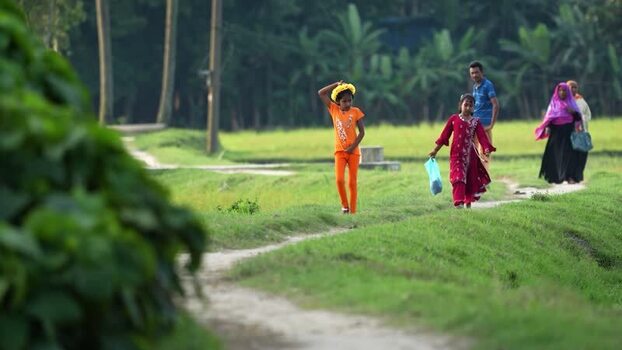 View of people walking on a rural path in Bogura Bangladesh.