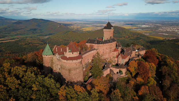 Aerial view of the medieval Chateau du Haut Koenigsbourg surrounded by vibrant autumn foliage and dense forests in the Vosges mountains Orschwiller Grand Est France.