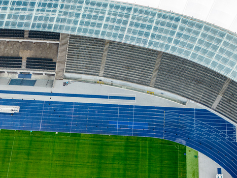 Berlin Germany 26 September 2026 Aerial view of Olympiastadion Berlin featuring the blue running track green grass field and stadium seating under a modern glass roof.