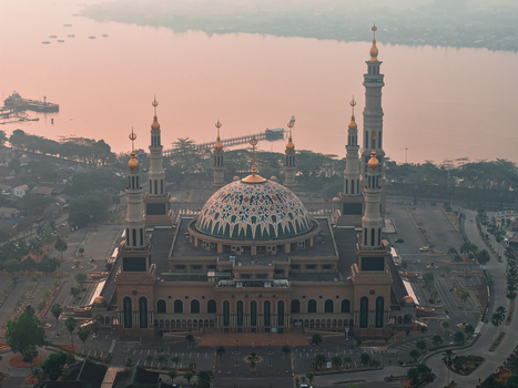 Aerial view of Baitul Muttaqien Mosque the East Kalimantan Islamic Center with its grand dome and minarets near the Mahakam River in Samarinda East Kalimantan Indonesia.