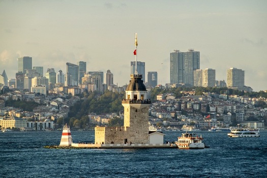 View of the historic Maiden s Tower situated on a small islet in the Bosphorus with the modern skyline of the city in the background under soft daylight Uskudar Istanbul Turkey. View of the historic Maiden s Tower situated on a small islet in the Bosphorus with the modern skyline of the city in the background under soft daylight Uskudar Istanbul Turkey.