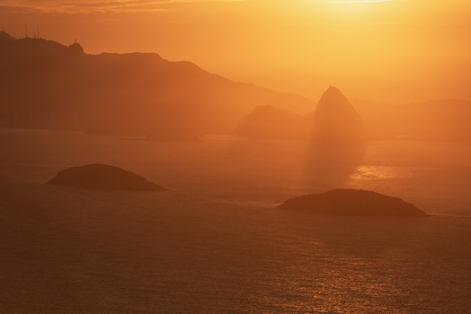 Aerial view of the iconic Sugarloaf Mountain silhouetted against a vibrant golden sunset over the Atlantic Ocean in Rio de Janeiro Rio de Janeiro Brazil. Aerial view of the iconic Sugarloaf Mountain silhouetted against a vibrant golden sunset over the Atlantic Ocean in Rio de Janeiro Rio de Janeiro Brazil.