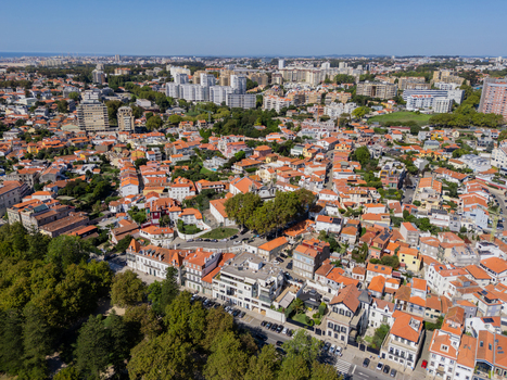 Aerial view of Igreja de Sao Joao Baptista da Foz do Douro surrounded by historic rooftops lush trees and urban streets in Porto Porto Portugal.
