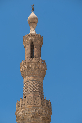 View of the intricate stone carvings on the minaret of Al Azhar Mosque against a clear blue sky Cairo Egypt. View of the intricate stone carvings on the minaret of Al Azhar Mosque against a clear blue sky Cairo Egypt.