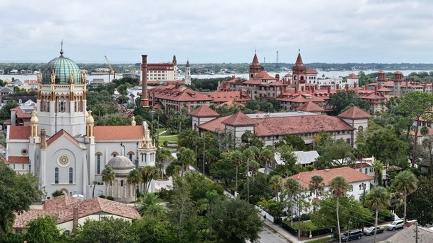 Aerial view of Memorial Presbyterian Church with its distinctive dome and historic architecture surrounded by lush palm trees and red tiled roofs in St. Augustine Florida United States.