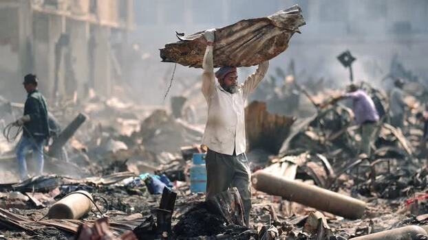View of a man carrying debris in a destroyed area in Bangladesh. View of a man carrying debris in a destroyed area in Bangladesh.
