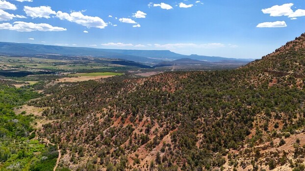 Collbran Colorado United States 04 July 2026 Aerial view of high desert mountain landscape with rolling hills sparse vegetation and rocky terrain under a blue sky. Collbran Colorado United States 04 July 2026 Aerial view of high desert mountain landscape with rolling hills sparse vegetation and rocky terrain under a blue sky.