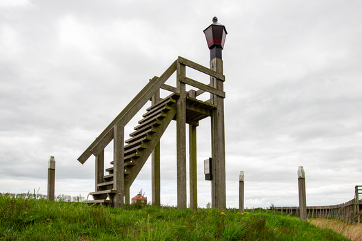 View of the historic wooden harbor light on a grassy hill under an overcast sky in Schokland Flevoland Netherlands.
