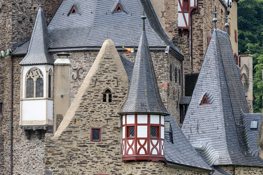 View of Eltz Castle featuring medieval stone walls pointed slate turrets and timber framed architectural details in Wierschem Rhineland Palatinate Germany.