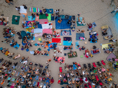 Varna Bulgaria 05 August 2026 Aerial view of Asparuhovo beach with a large crowd of people sitting on blankets and chairs during an outdoor event on the sand.