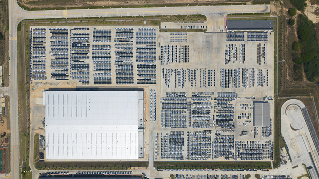 Aerial view of the BYD Thailand Rayong Office Building and a massive parking lot filled with thousands of new vehicles in Phananikhom Rayong Thailand.