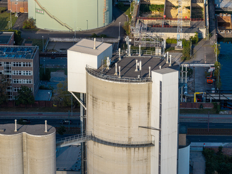 Aerial view of the Zementwerk Berlin concrete industrial facility featuring large cylindrical silos and metal structures situated in an urban industrial zone Berlin Berlin Germany. Aerial view of the Zementwerk Berlin concrete industrial facility featuring large cylindrical silos and metal structures situated in an urban industrial zone Berlin Berlin Germany.